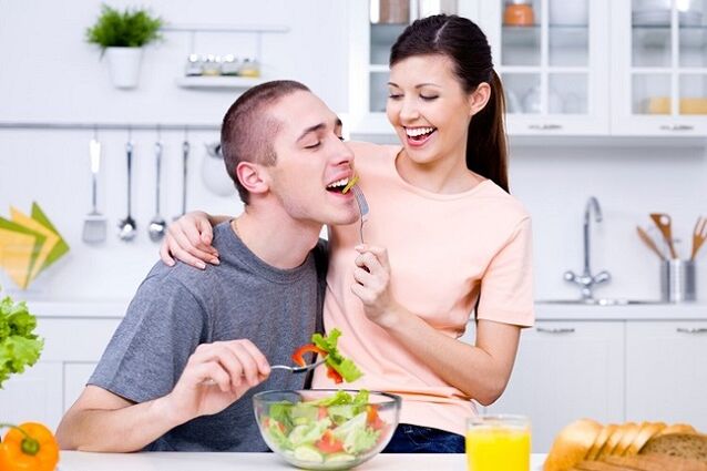 la fille nourrit l'homme avec une salade de vitamines pour la puissance